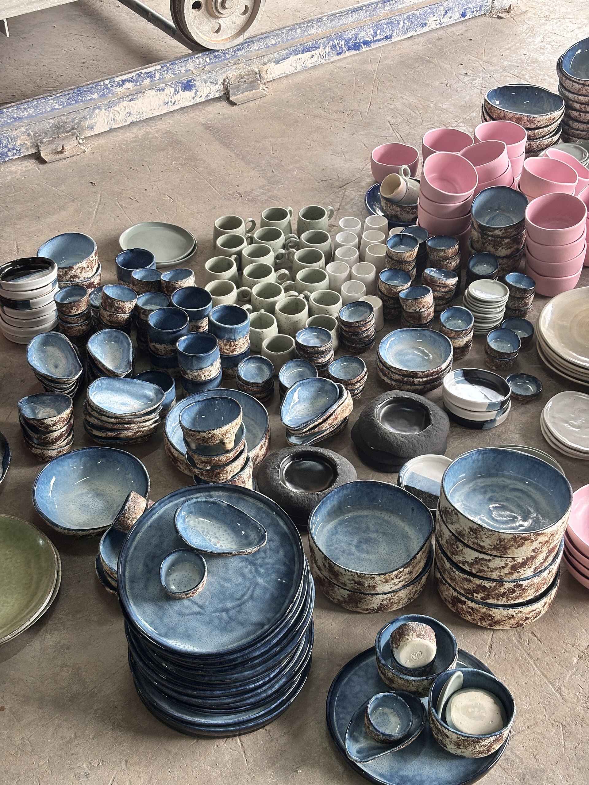 An assortment of ceramic tableware in cream, sand, and warm brown tones