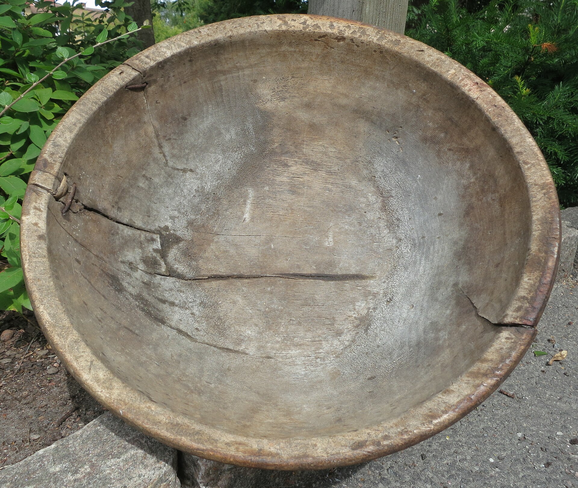 A turned wooden bowl with a smooth oiled finish on a neutral surface